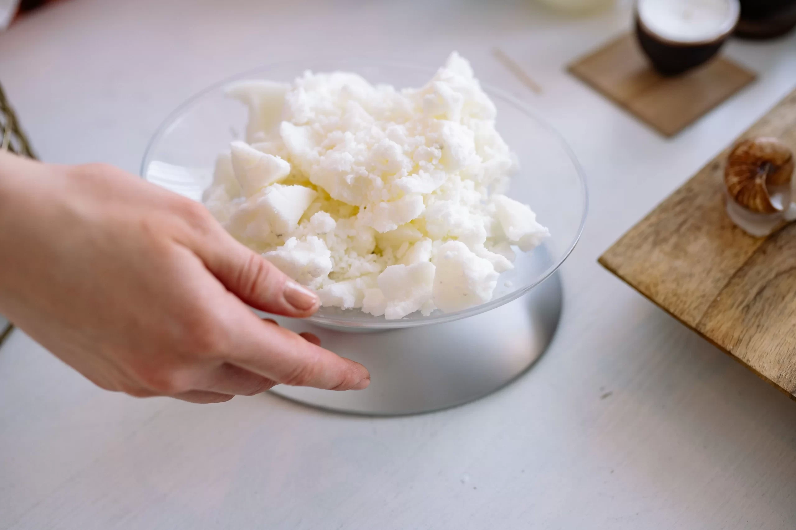Creamy unrefined Nilotica shea butter being scooped to show its soft Grade A cosmetic texture.